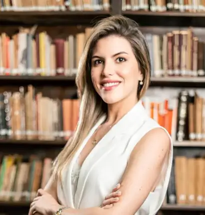 Jimena Irun en la biblioteca del estudio, frente a libros de leyes simbolizando el cumplimiento normativo en derecho laboral.